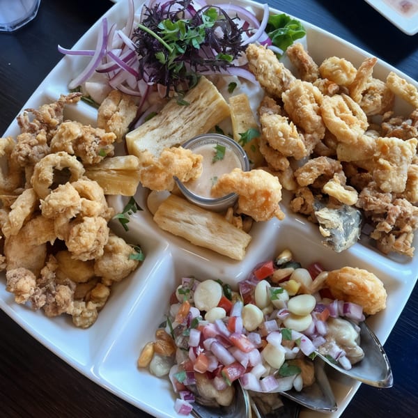 Peruvian seafood platter with fried calamari, yuca, ceviche, and red onion salad.